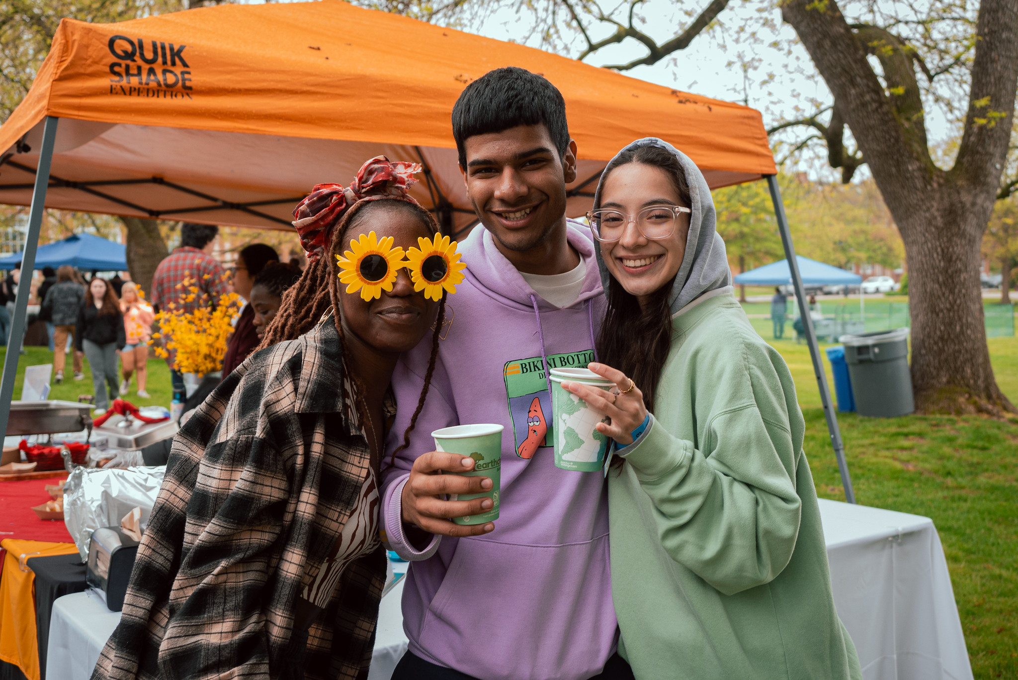 3 students posing at International Food Fest with drinks in hand